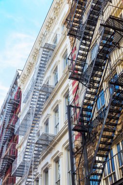 old residential buildings with fire escape stairs in Soho, New York City clipart