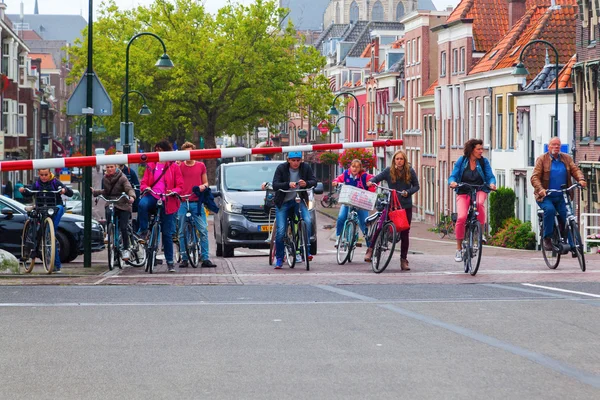 Fietsers te wachten op een basculebrug in Delft, Nederland — Stockfoto