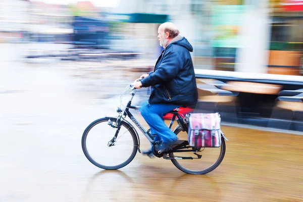 Ciclista em um dia chuvoso em uma cidade holandesa — Fotografia de Stock