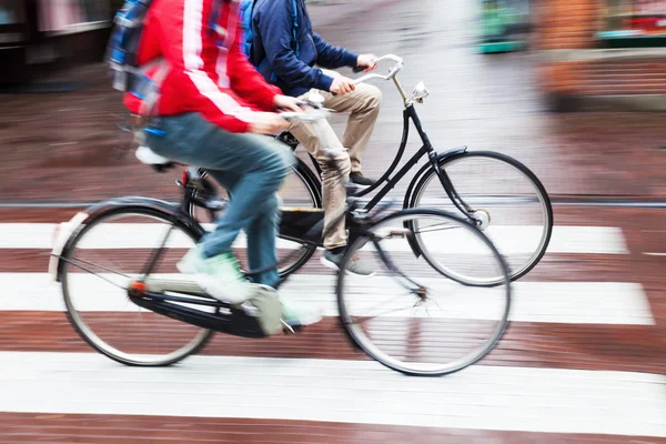 雨の多い街で自転車に乗る人 — ストック写真