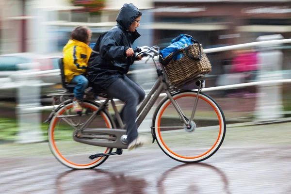一个下雨天的自行车骑手，在荷兰的城市 — 图库照片