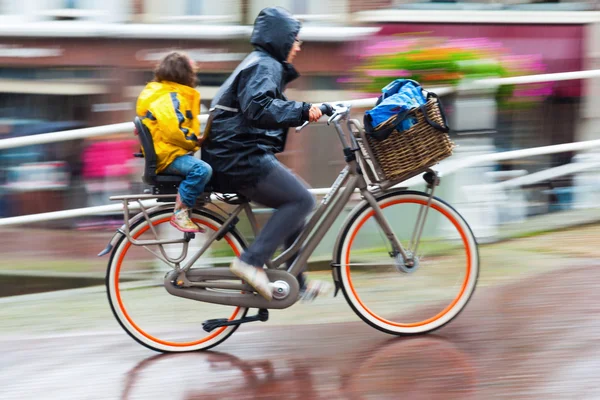 一个下雨天的自行车骑手，在荷兰的城市 — 图库照片