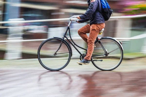 Fahrradfahrer in der verregneten Stadt — Stockfoto