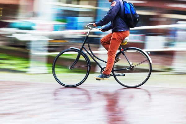 雨の多い街で自転車に乗る人 — ストック写真