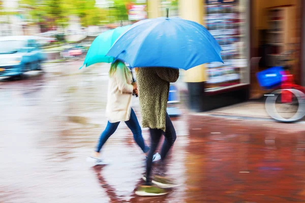 Vrouwen met paraplu's lopen in de regenachtige stad — Stockfoto