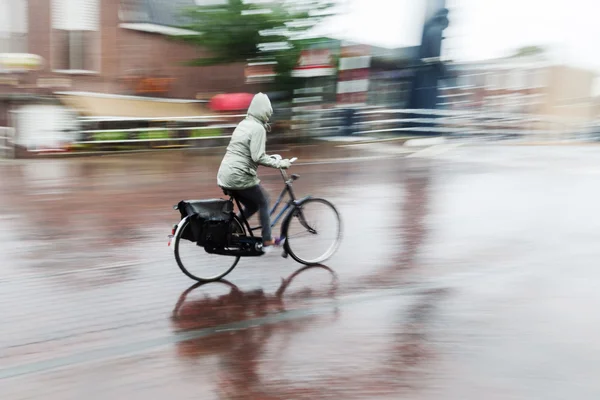 骑自行车的人在雨中 — 图库照片