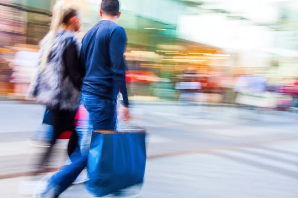 Shopping människor i staden i rörelse oskärpa — Stockfoto