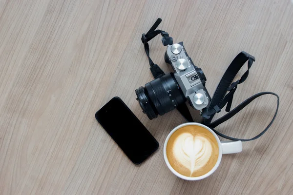 Kamera mobiltelefon och latte art — Stockfoto