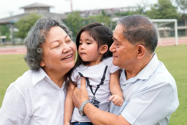 asian grandfather and grandmother hug children