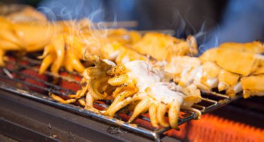 Mürekkep balığını yakın Tayland 'ın sokak yemeklerinde barbekü rafında yakalım.