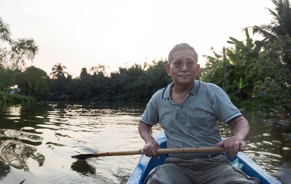 senior old asian man roll boat in the river in long life active outdoor activity concept