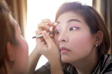 Asyalı kadın sabah işe gitmeden önce makyajını yapmış.