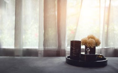 Oturma odasında pankart büyüklüğünde çiçek ve çay sepetinin sade bir fotoğrafı.