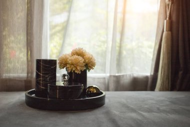 Oturma odasındaki pankartlı sazanın ve çiçeğin sade bir fotoğrafı.