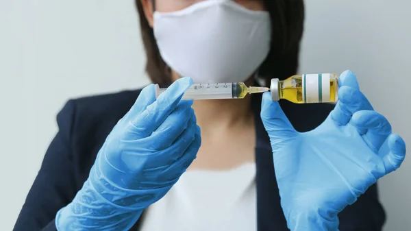 close up hygine hand with doctor glove pulling syringe of vaccine drug on white background