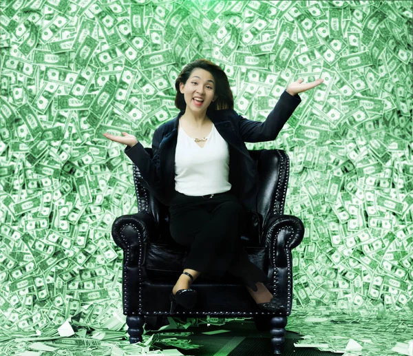 Happy Asian woman sitting on a chair full of money like a millionaire From winning the lottery or business rewards