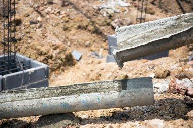 Yeni bir bina inşaatı. Beton borular betondan temel sütunlar yapıyor.