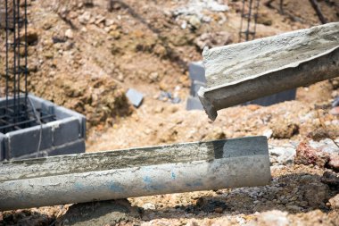 Yeni bir bina inşaatı. Beton borular betondan temel sütunlar yapıyor.
