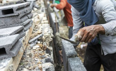 İnsan gücü ve çimento ile güvenli ev için tuğla duvar çiti yapmak