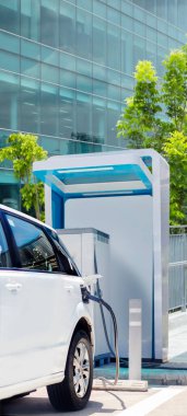 Modern yapı üzerindeki temiz enerji teknolojisi konsepti için otomobil için yeşil enerjiyi elektrikli arabaya dikey pankartta yüklemek (yolu da kapsar)
