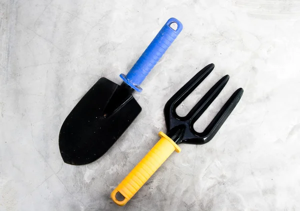 Gardening tools, black iron rake and scoop with plastic handle — Stock Photo, Image