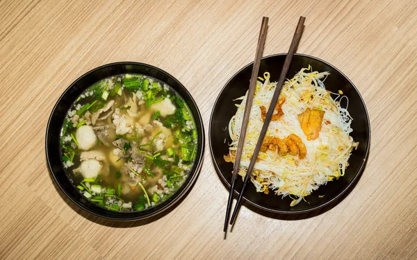 Nouilles blanches et soupe de porc dans un bol noir avec bâton de bois — Photo