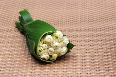 White jasmine flowers on banana leaf and brown net clipart