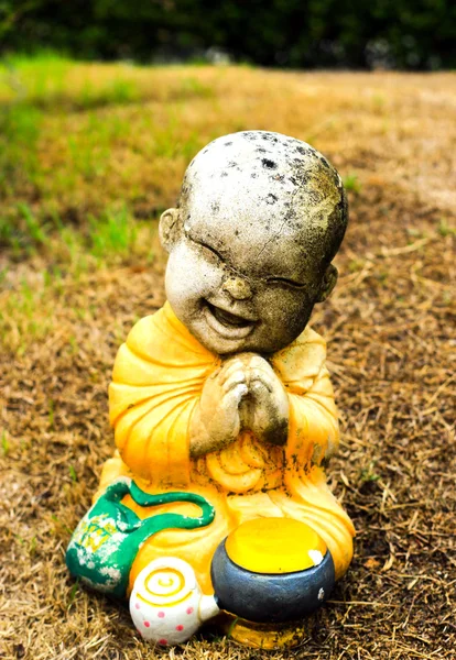 Little monk statue on grass — Stock Photo, Image