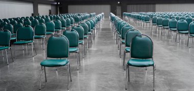 Bir seminer ya da iş etkinliği için büyük bir konferans salonunda sıralanmış deniz mavisi sandalyeleri. Simetrik oturma düzeneği ve geniş iç mekanı olan profesyonel iç mekan