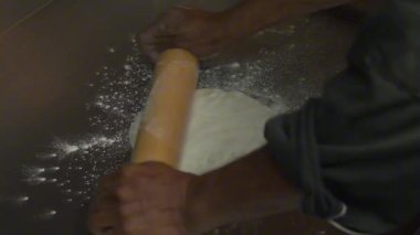 Profesyonel aşçı ellerinin yoğurmasını ve taze pizza hamurunu unla esnetmesini sağlayın. Restoran ve mutfak video üretimi için otantik İtalyan pişirme süreci