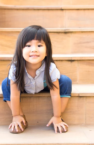 Chica asiática sonrisa sentado en amarillo escaleras — Foto de Stock