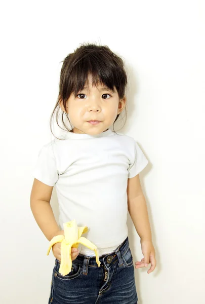 Ásia menina comer banana — Fotografia de Stock