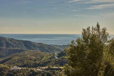 Yeşil dağlar ve vadiler berrak bir gökyüzünün altında sakin Akdeniz ile buluşuyor.