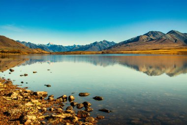 Güney Alpleri 'nin karlı zirveleri Clearwater Gölü, Ashburton Gölleri' nin yüksek kesimindeki sakin sulara yansıdı.