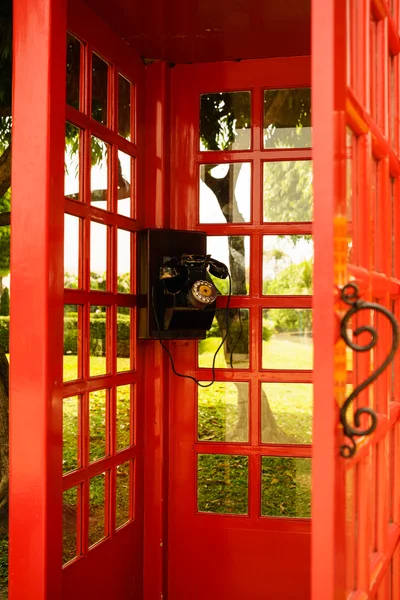 Antiguo teléfono de línea clásica en cabina de madera roja — Foto de Stock