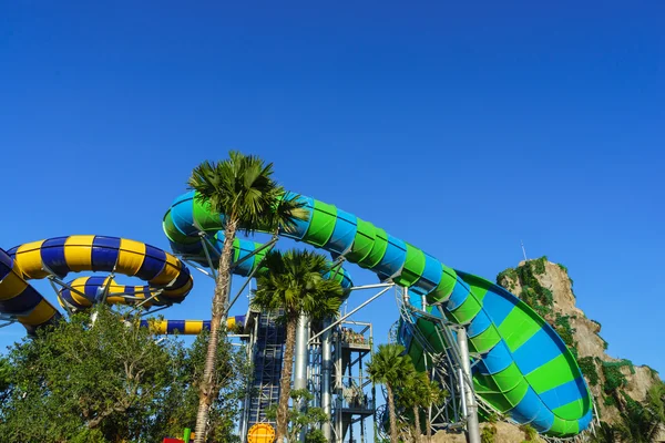 Enormes toboganes de tubo de agua de la selva en el parque temático del agua parecen salir y son atracciones perfectas tanto para jóvenes como para adultos durante las vacaciones. Los visitantes y turistas disfrutan de las curvas y la velocidad mientras juegan Imágenes de stock libres de derechos