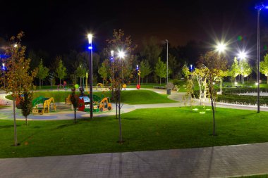 Boş Park Sahil Meydanı (Pribrezhnyy Meydanı) gece aydınlığında. Oyun parkı. Dnipro şehri, Ukrayna. Modern şehir manzarası, şehir planlaması, modern mimari