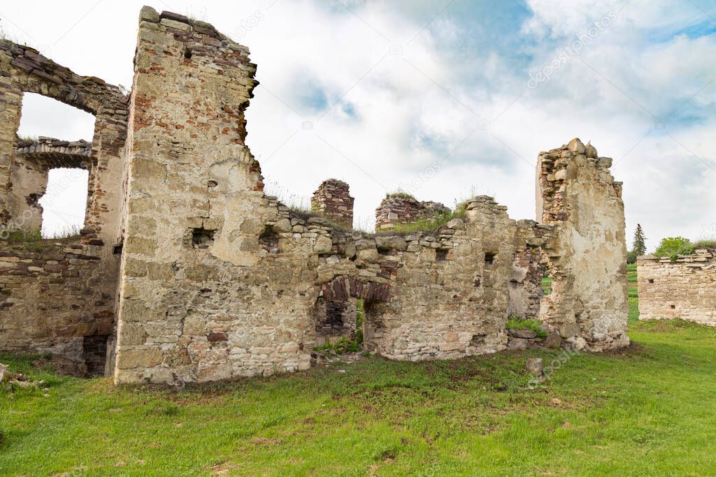 Scenic ruins of ancient castle Pidzamochok among green grass. Buchach region, Ternopil Oblast, Ukraine. Tourist landmark, tourist destination