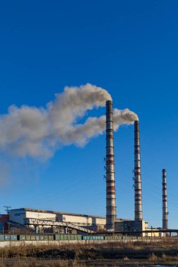 Kömürle çalışan elektrik santrali. Burshtyn şehri. Batı Ukrayna. Mavi gökyüzü arka planındaki kömür yakma santralindeki duman yığınları. Çevre kirliliği