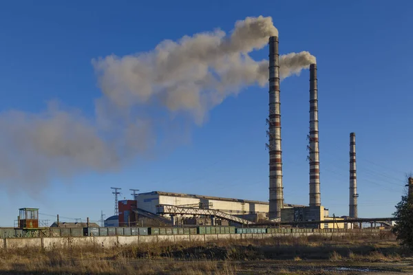 Kömürle çalışan elektrik santrali. Burshtyn şehri. Batı Ukrayna. Mavi gökyüzü arka planındaki kömür yakma santralindeki duman yığınları. Çevre kirliliği