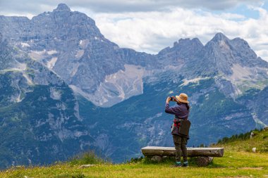 Kadın, Rifugio Citta Di Carpi yakınlarındaki Dolomites arazisinin fotoğrafını çekiyor. İtalya. Dağların zirvesi. Yürüyüş için ünlü turizm beldesi
