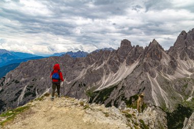 Yaz aylarında Tre Cime di Lavaredo dağ manzarası. Dağın tepesinde kadın yürüyüşçü. Cortina d'Ampezzo . Dolomitler. İtalya. Yürüyüş için ünlü turizm beldesi