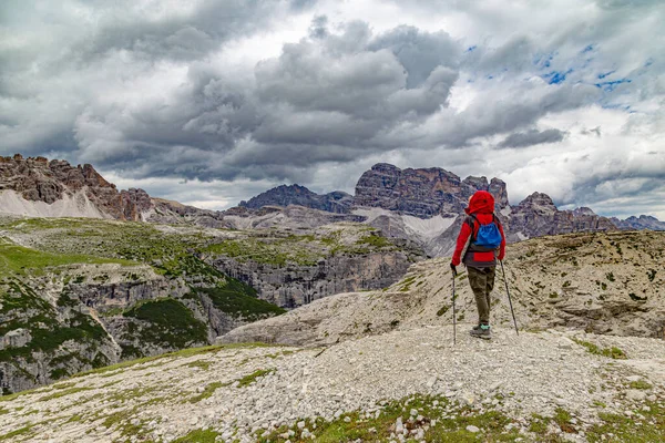 Yaz aylarında Tre Cime di Lavaredo dağ manzarası. Dağın tepesinde kadın yürüyüşçü. Cortina d'Ampezzo . Dolomitler. İtalya. Yürüyüş için ünlü turizm beldesi