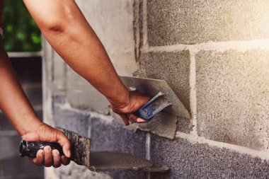 Beton alçıcılar endüstriyel işçilerin arka plan duvarlarını alçılama araçlarıyla donatmak için.