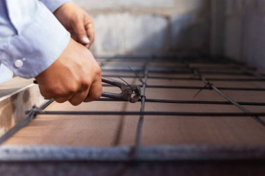 Çelik destekli betonu bağlayan inşaat işçileri.