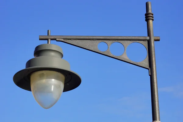 Черный фонарный столб с голубым небом — стоковое фото