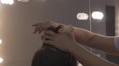 Orta yaşlı bir kadın kaşını bir kalemle boyuyor. Asyalı kaşlarının şeklini kendisi çiziyor. Yüksek kalite 4k görüntü