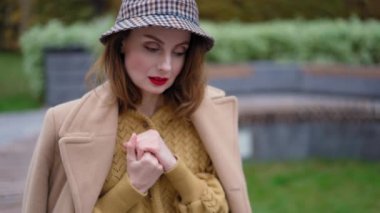 Şehir arka planında açık kahverengi saçlı, donmuş bir kız. Soğuk havada duran güzel kız ellerini ovuşturur. Avuçlarını ısıtmaya çalışır. Randevu ya da kız arkadaş bekler. Yüksek kalite 4k görüntü