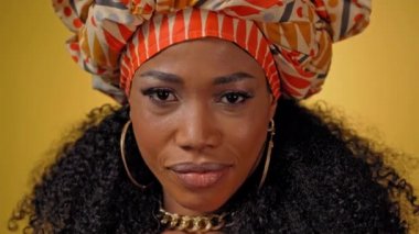 Sarı arka planda soyutlanmış görünen, ulusal bir başlık takan güzel Afro-Amerikan genç bayanı kapatın. Yüksek kaliteli 4k çözünürlük görüntüleri