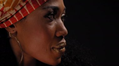 Siyah arka planda izole edilmiş kameraya bakan geleneksel Afro-Amerikan kadın başlığını kapatın. Yüksek kaliteli 4k çözünürlük görüntüleri